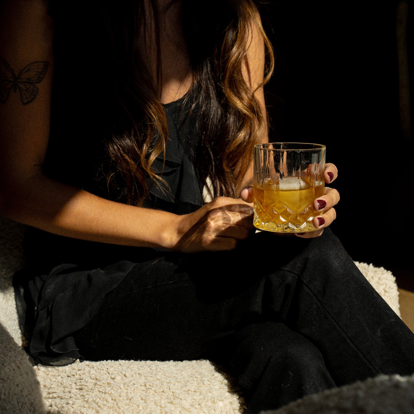 Model holding a glass of whiskey. 